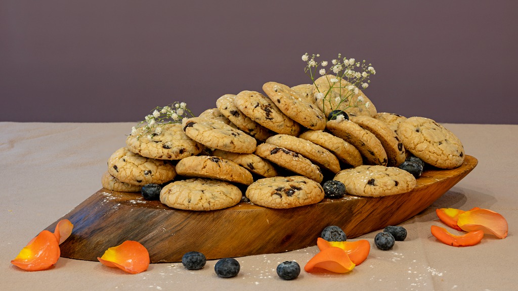 Chocolate chip cookies stacked on a wooden board