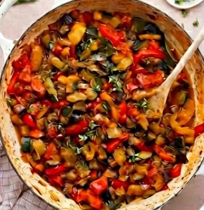 A large pan of ratatouille with peppers, aubergine and courgette